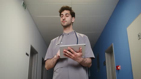 médico usando una tableta en el pasillo del hospital