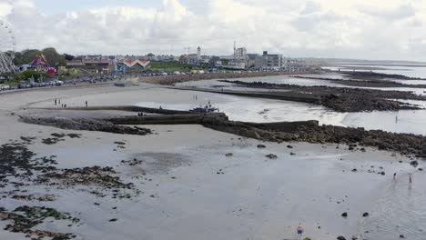 El-Dron-Se-Eleva-Por-Encima-De-La-Línea-De-Agua-De-La-Marea-Baja-En-Ladies-Beach,-Revela-La-Costa-Irlandesa-De-Galway-Y-El-Paseo-Marítimo-De-Salthill