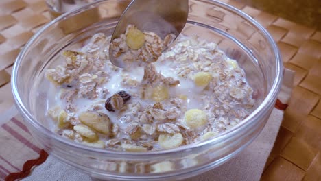 whole grain cereal muesli in a bowl for a morning delicious breakfast with milk. slow motion with rotation tracking shot.