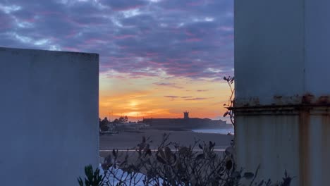 colourful sunset skyline over silhouette city at dusk with dramatic orange red yellow sky and clouds moving over city