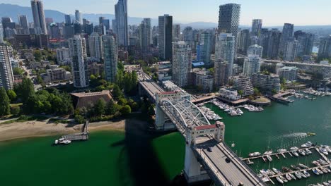 Cars-Driving-Through-The-Burrard-Bridge-With-Downtown-Vancouver-Skyline-In-BC,-Canada