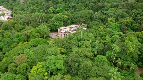 Aerial-orbit-establishing-of-the-Palace-hidden-in-the-vegetation-of-Lage-Park,-Rio-de-Janeiro-Brazil