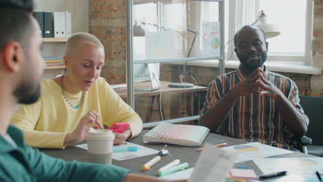 african american man in wheelchair talking with business team at office meeting