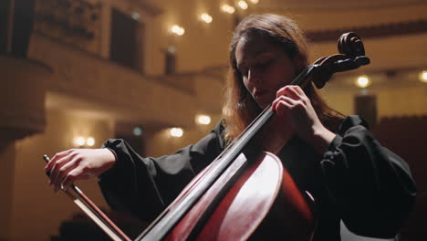 female violoncellist is playing music in philharmonic hall concert of classic music woman cellist