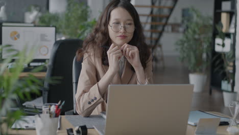 mujer trabajando en una computadora portátil en una oficina moderna