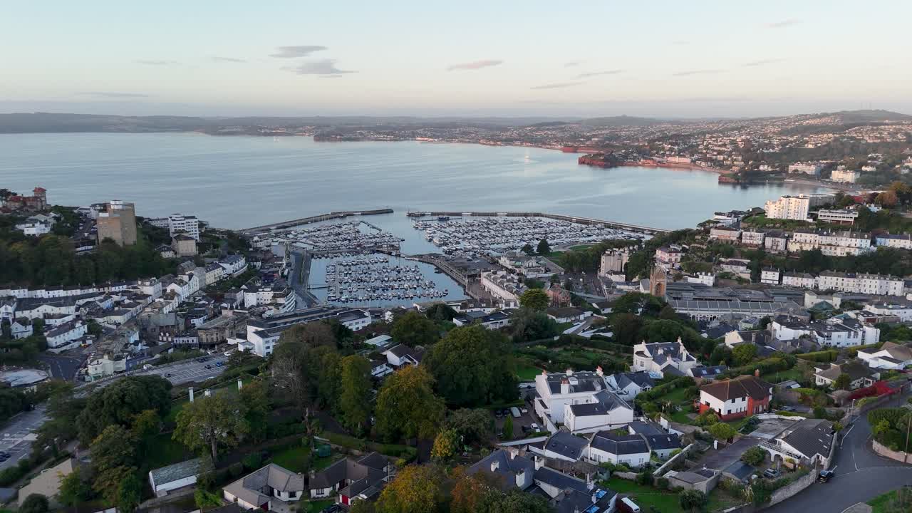 Cinematic aerial drone footage with smooth sideways truck slide movement over Torquay Marina showcasing boats harbor bay waterfront and coastal town in Devon England