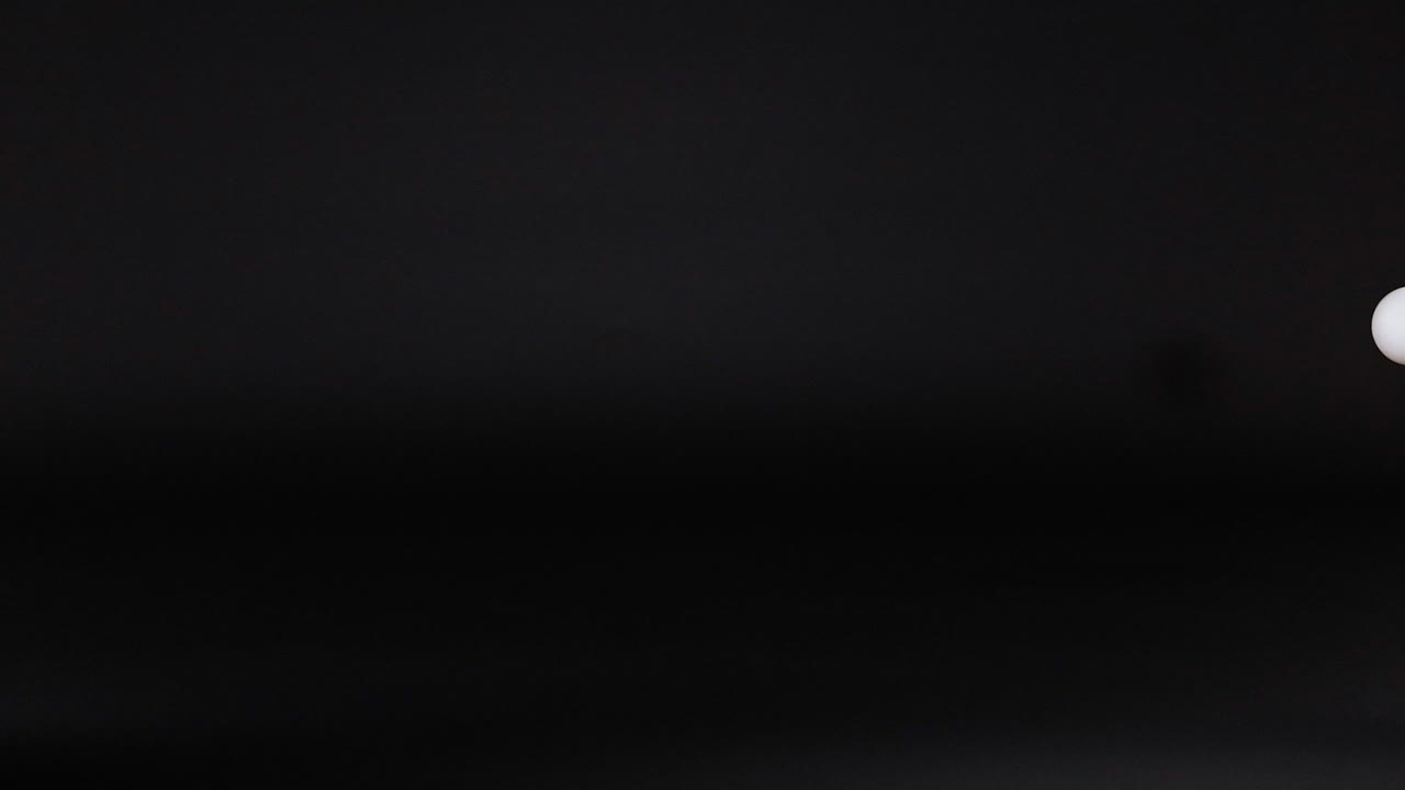 bola de ping pong rebotando en el espacio oscuro