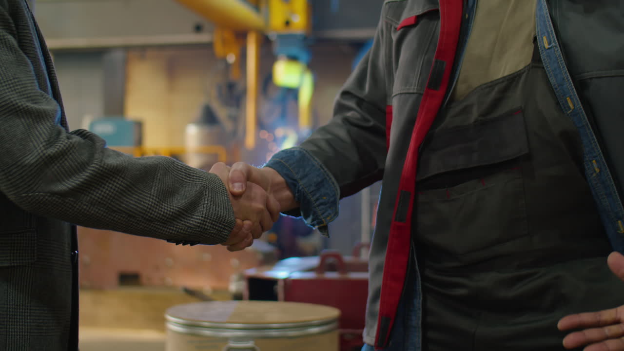 Senior Engineers Shaking Hands in Factory