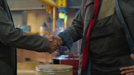 senior engineers shaking hands in factory
