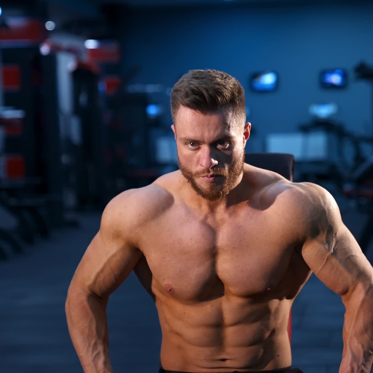 Athletic body. Shirtless model guy is posing to the camera. Strong muscular man with perfect body