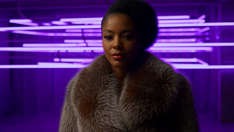 woman in fur coat against purple neon lights