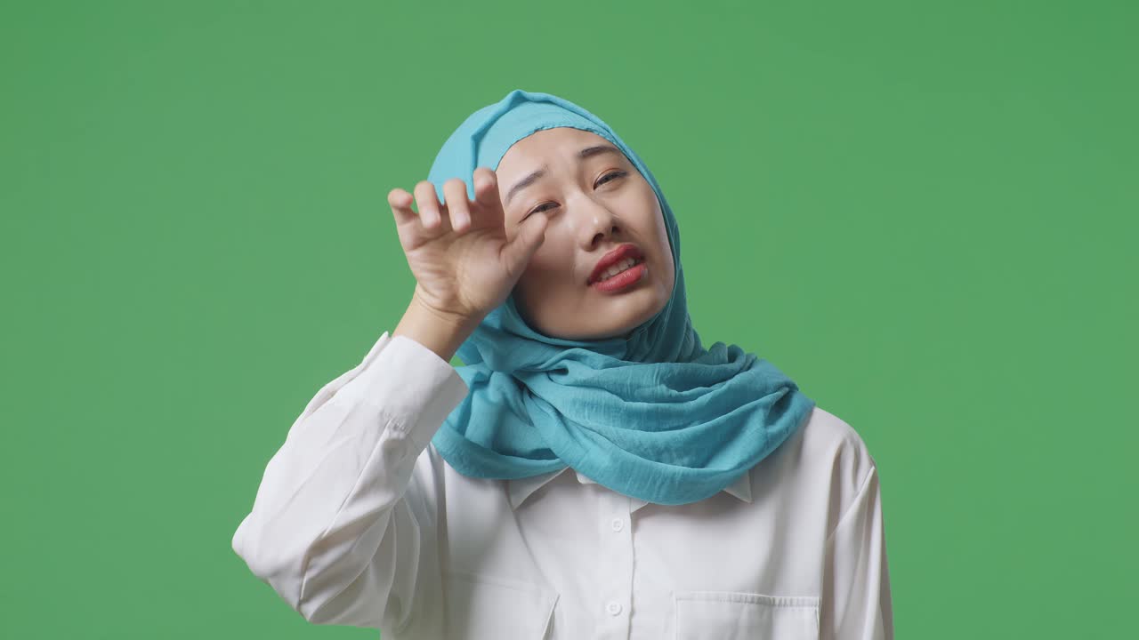 녹색 스크린 배경 스튜디오에 서서 을 고 피곤한 아시아 무슬림 여성의 클로즈업