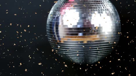 Digital-animation-of-confetti-falling-over-silver-spinning-disco-ball-against-black-background
