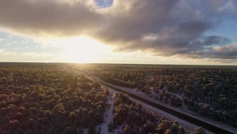 Antena-De-4k-Sobre-Un-Remoto-Camino-Forestal-De-Invierno-Durante-Un-Hermoso-Amanecer-Colorido