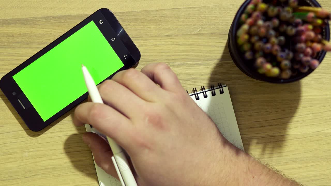 The specialist is sitting at the desk. Using the Internet through a tablet. Green screen.