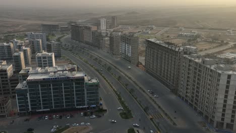 aerial flying back over apartments and building developments bahria town in karachi during sunset