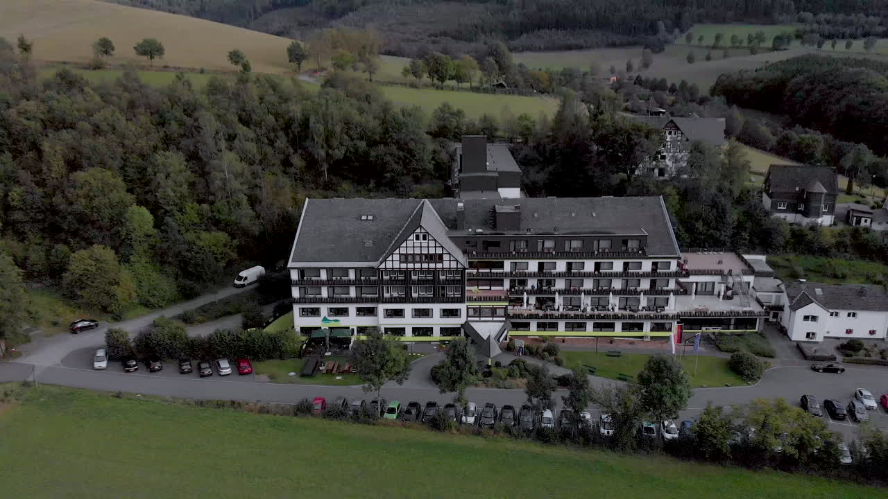 Aerial view of the Alpin hotel in the spa and ski village of Grafschaft in the Sauerland region near Winterberg against a blue sky with clouds