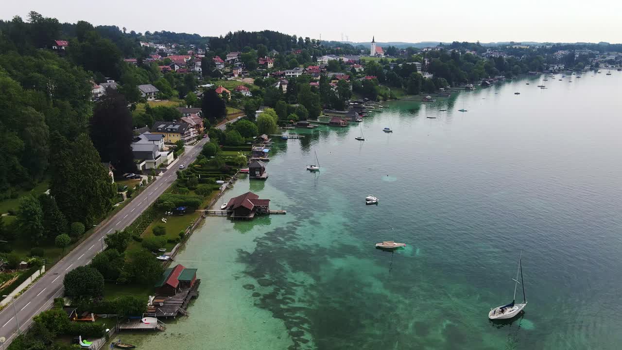 Coastal Austrian town rests beside green lake under cloudy summer sky, Attersee
