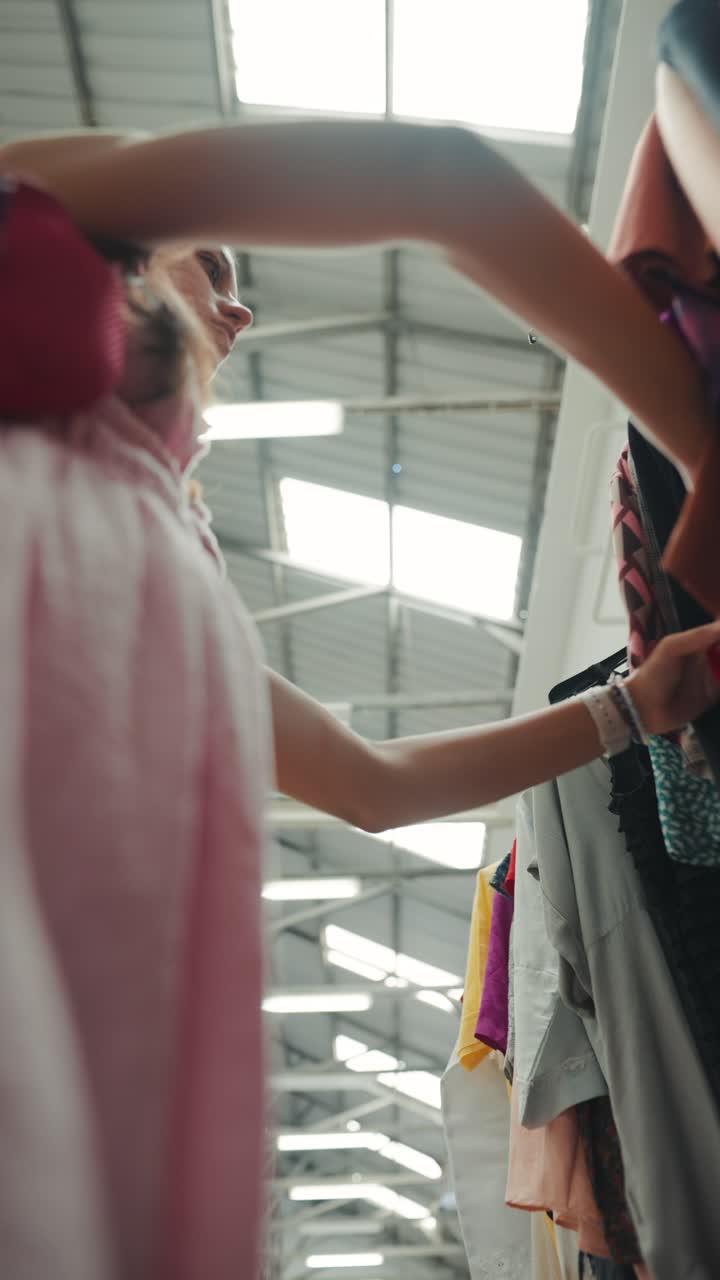Woman selecting clothes from rack