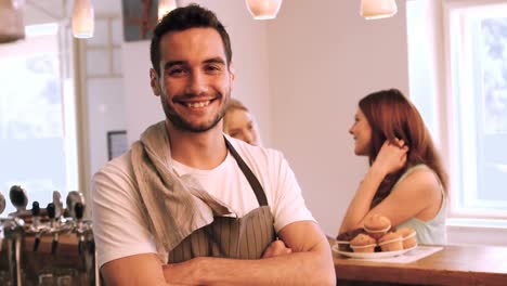 Portrait-of-smiling-waiter-standing-with-arms-crossed