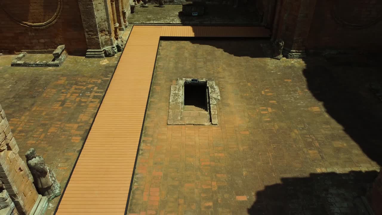 un dron corto se aleja de una pequeña cripta dentro de una ruina jesuita en paraguay con la jungla en el fondo