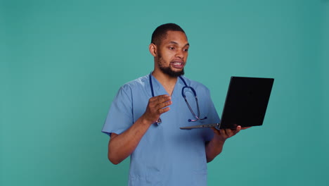 Hospital-staff-member-listening-to-patient-in-videocall-using-laptop