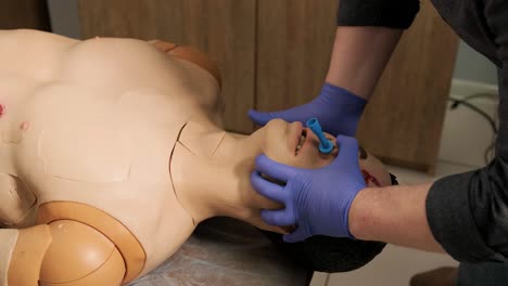 el médico táctico cubre la herida con un vendaje en el maniquí.