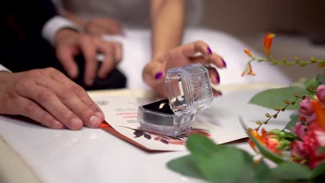 wedding rings and invitation, bride and groom hands. static, shallow focus