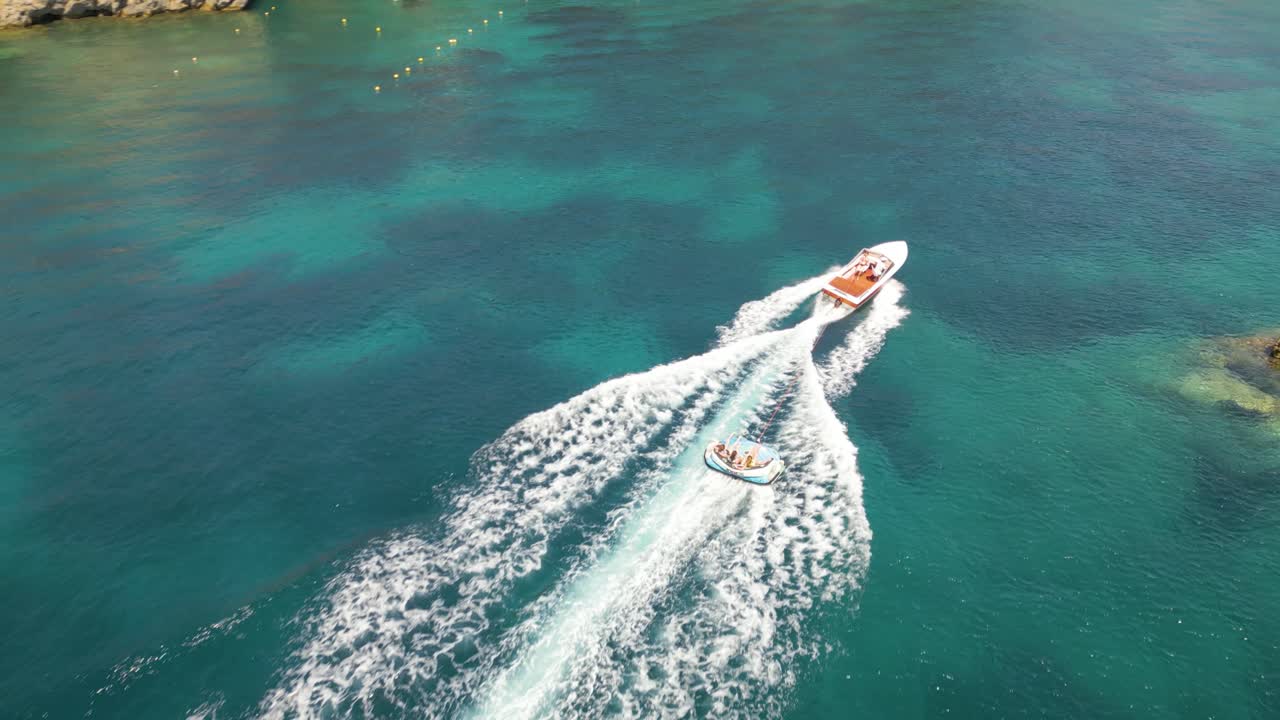 파란 물 위에서 배로 끌려가는 사람들과 함께 튜빙 보트