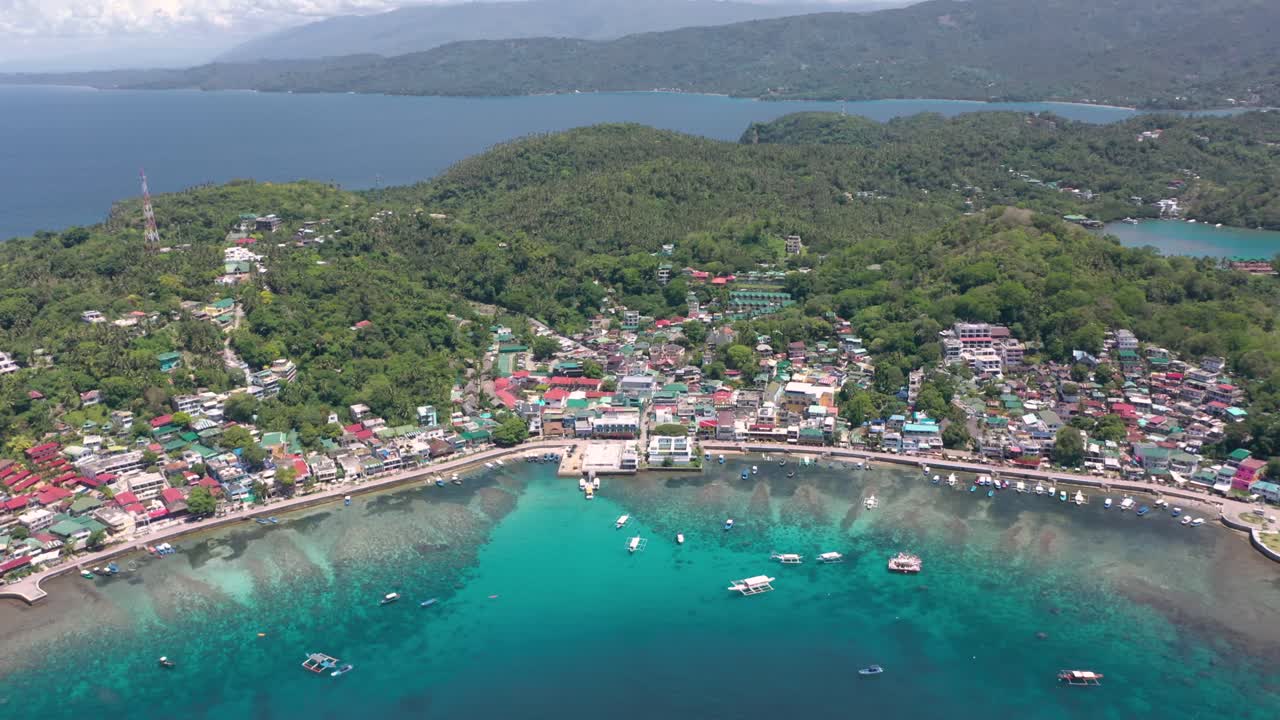 Aerial of Puerto Galera and Sabang Bay with turquoise waters, boats, and diving schools, showcasing the tropical beauty of this famous Philippine destination