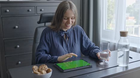Happy-woman-swiping-on-tablet,-green-screen