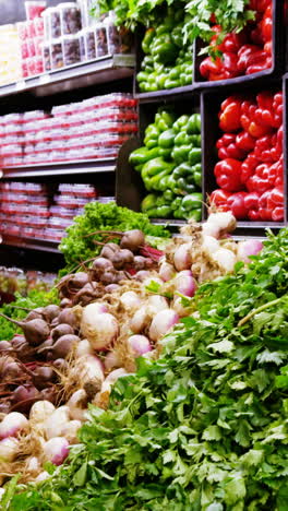 woman selecting vegetables from organic section