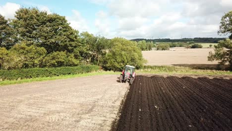 aerial footage over tractor ploughing field