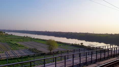 Personenzug,-Der-Am-Morgen-Auf-Gleisen-über-Den-Fluss-Fährt.-Das-Video-Wurde-Am-4.-August-2022-Am-Bahnhof-Neu-Delhi-Aufgenommen