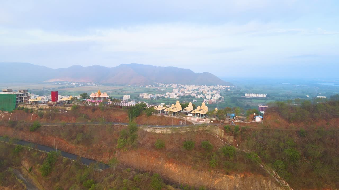 una toma aérea de vijayawada en las tranquilas primeras horas, con la luz del sol atravesando las nubes de la mañana para revelar la ciudad.