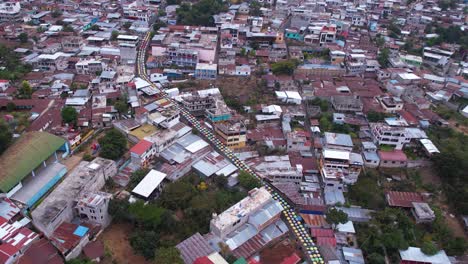 san juan la laguna, guatemala. revealing drone shot of town on coast of lake atitlan from umbrella street