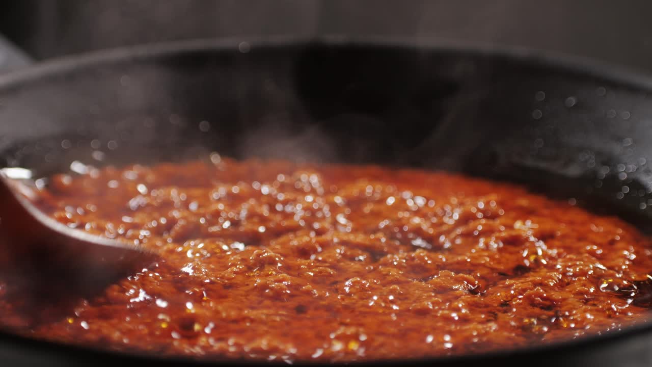 Cooking tomato sauce close-up. Classic homemade Italian tomato sauce for pasta and pizza in the pan. Chef cooking traditional Italian food. High quality 4k footage