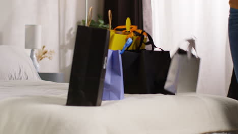 woman with shopping bags in bedroom