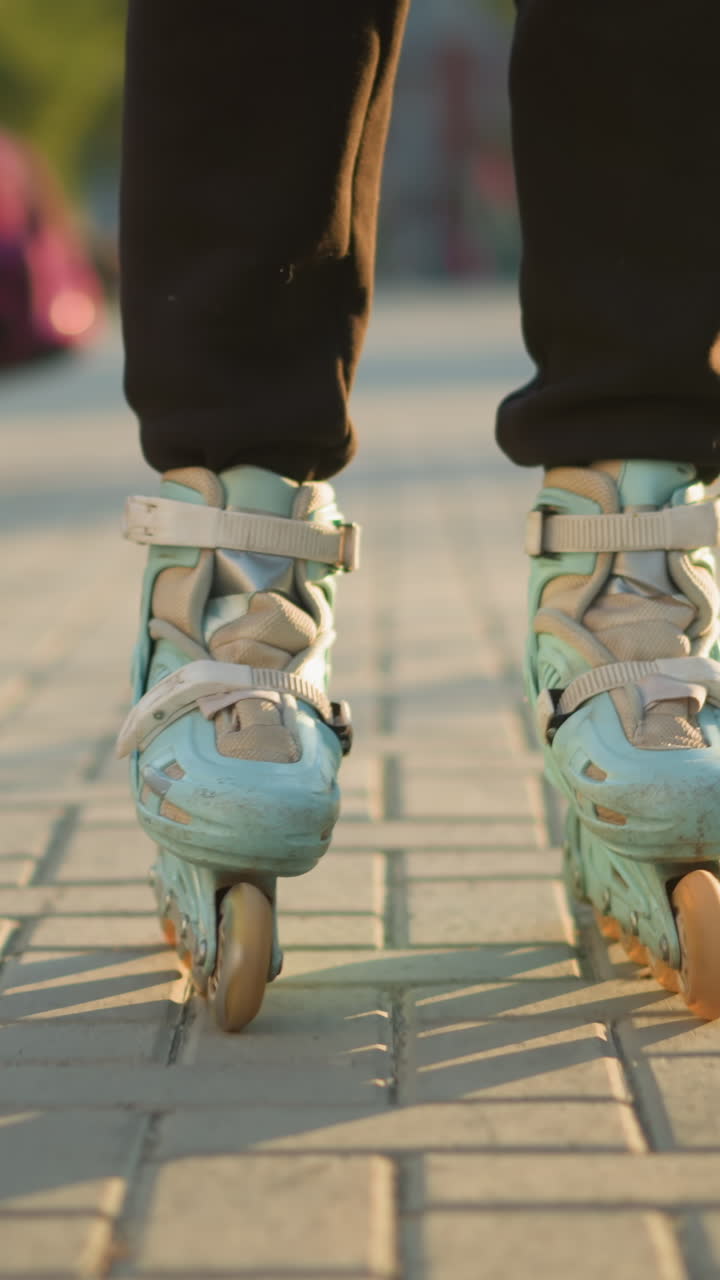 A close-up shot of a person s feet wearing rollerblades, gliding smoothly on a paved path in a park , with other people visible in the blurred background