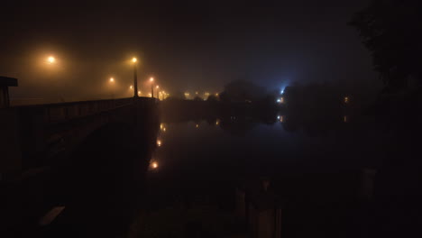 manes bridge over vltava river with street lamps at night in mist,prague,czechia