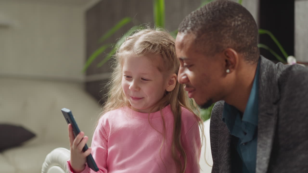 Una bambina mostra video tramite smartphone a un'insegnante allegra