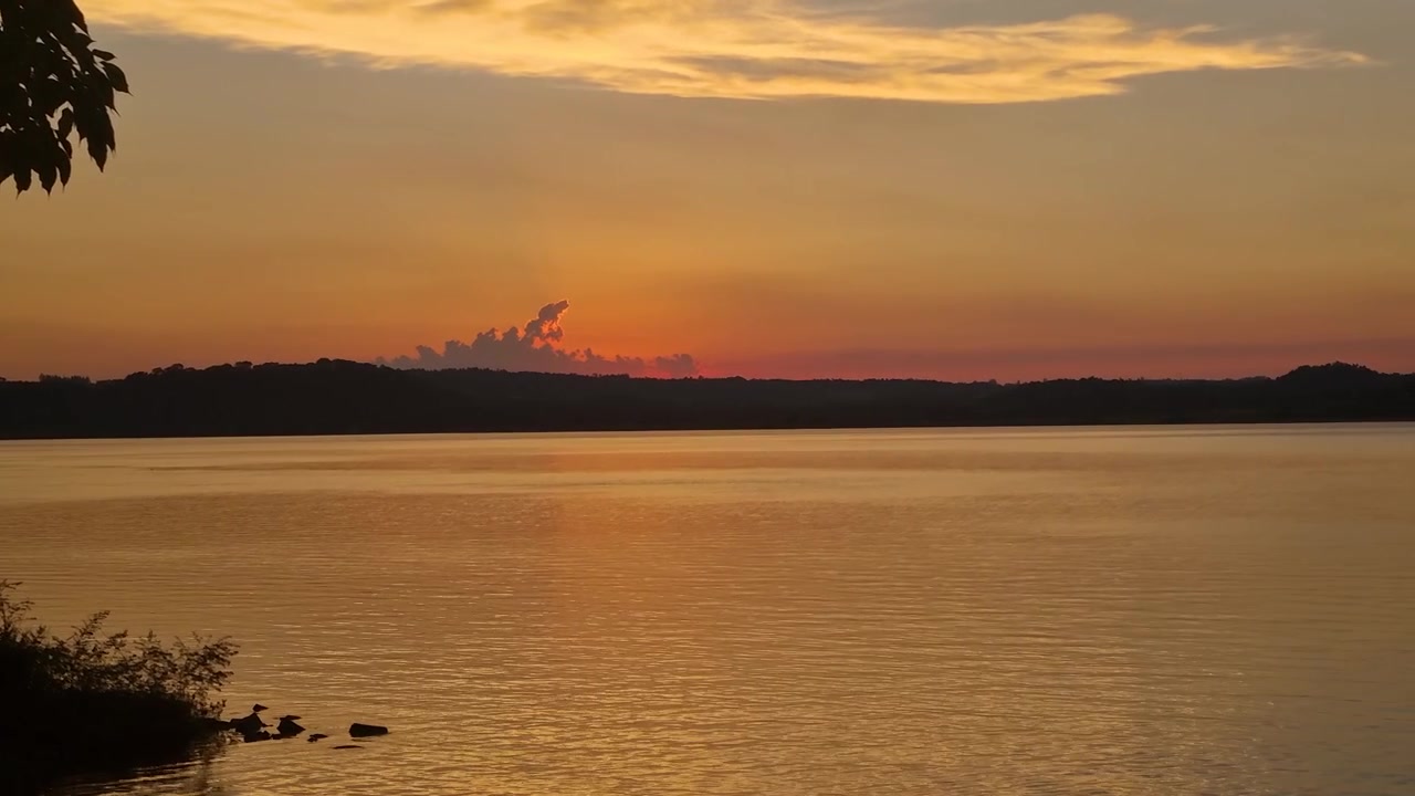 View over Río Paraná near Playa del Sol beach just after sunset, San Ignacio, Argentina, with Paraguay across the calm river, tropical natural scenery, and serene waterscape