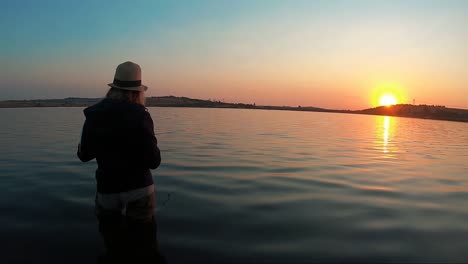 Ansicht-Des-Schönen-Mädchenfischens-Mit-Einem-Schönen-Sonnenuntergang-Im-Hintergrund-In-Südafrika