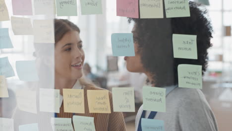 creative-business-women-using-sticky-notes-brainstorming-colleagues-working-together-problem-solving-discussing-solution-enjoying-teamwork-in-startup-office