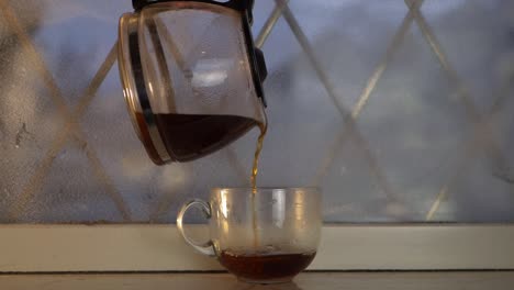 Einschenken-Von-Frisch-Gebrühtem-Heißen-Kaffee-Im-Winterfenster-Mittlerer-Schuss