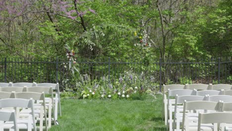 pov walking down grassy outdoor wedding venue aisle towards large floral ring altar