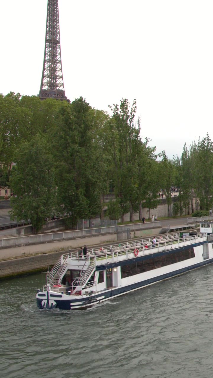 Un battello da crociera passeggeri naviga lungo il fiume Senna, passando davanti alla Torre Eiffel a Parigi.