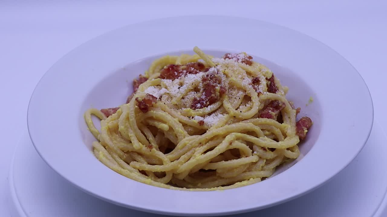 Italian spaghetti alla Carbonara in a white plate. The real Carbonara recipe