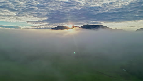 sunrise over mountain peaks while flying above clouds but below cirrocumulus layer of the atmosphere