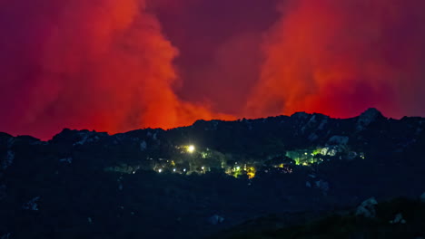 panoramic landscape of a wildfire near city lights, red skyline, smoke burning, environmental disaster, fire blowing near valley village